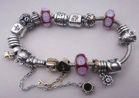 Auktion 349 / Los 1027 <br>Pandora Silberarmband mit vielen Charms, meistens Silber-925-, tw. vergoldet, zus. 68 gr., 3x Glas, meisten wohl ebenfalls Pandora