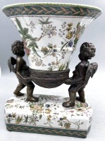 Auktion 354 / Los 9013 <br>gr. Fayence Schale, getragen von 2 Putti aus Bronze, unged. Marke und chines. Zeichen?, H-27 cm, B-ca. 23 cm, Schale oben 20x17 cm,