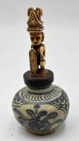 Auktion 355 / Los 15520 <br>kl. Tiegel mit Blaumalerei, Holzstöpsel  mit Figur beschntitzt?, wohl China/Tibet, H- gesamt 12,5 cm, Keramik 6,5 cm