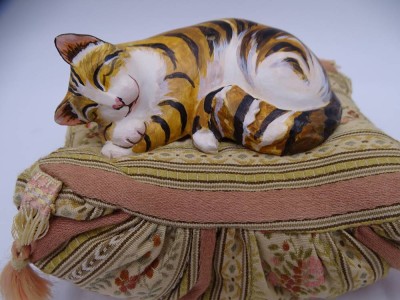 Auktion 349<br>Spieluhr mit schlafender Katze auf Kissen, Werk läuft, H-9 cm, 14x11 cm [1]