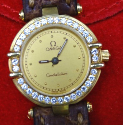 Auktion 355<br>Damen-Armbanduhr, Omega Constellation, 750er Gelbgold, Modell Manhatten Chronometer, Lünette mit Brillantbesatz, Quartzwerk, zus. 21gr., Lederband, D-2,2cm [1]